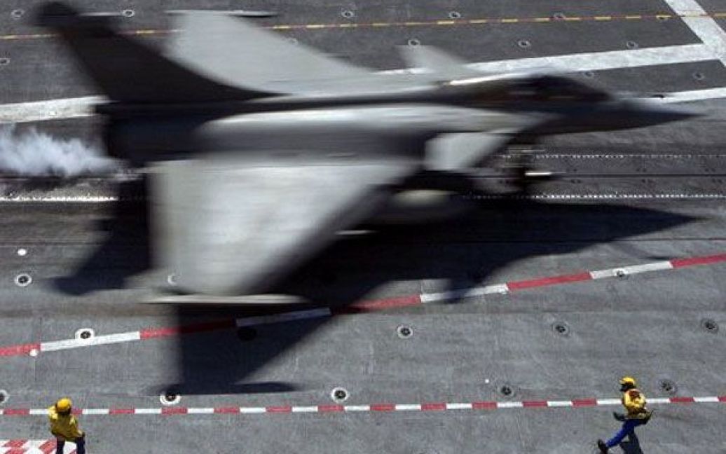 Середземне море. Винищувач Dassault Rafale французьких ВМС сідає на французький авіаносець "Шарль де Голль" перед вильотом до Лівії, де він візьме участь у військовій операції Harmattan. / © AFP