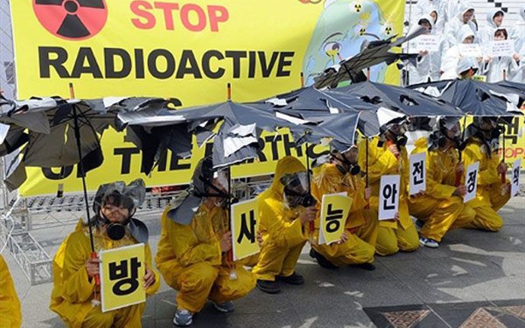 Республіка Корея, Сеул. Південнокорейські активісти екологічного руху у жовтих плащах, протигазах та з розірваними парасольками беруть участь у мітингу проти будівництва атомних електростанцій в Сеулі. / © AFP