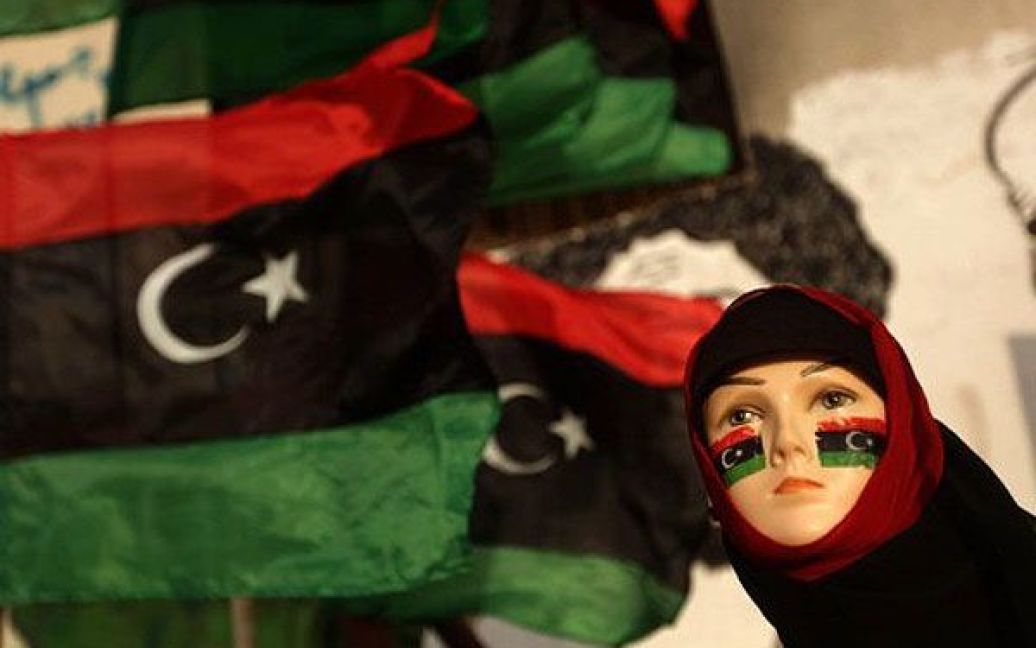 Лівійська Арабська Джамахірія, Бенгазі. Жіночий манекен у хіджабі з розмальованими у кольори колишнього лівійського прапора щоками виставлений у вітрині вуличного торговця в повстанському місті Бенгазі. / © AFP