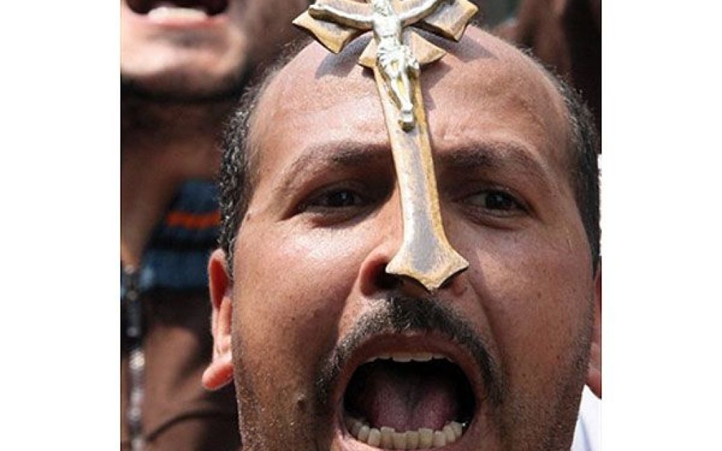 Єгипет, Каїр. Єгипетський християнин бере участь в акції протесту перед будівлею державного ТБ в Каїрі. Християни влаштували тижневий сидячий страйк після того, як 78 осіб отримали поранення у релігійних зіткненнях і сектантських заворушеннях. / © AFP