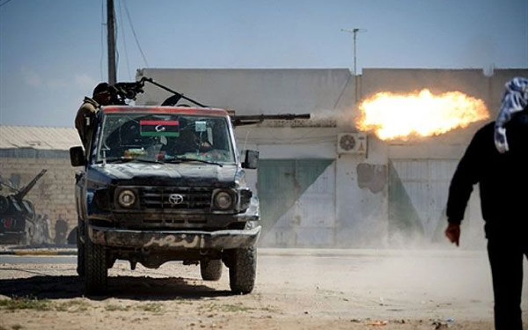 Лівійська Арабська Джамахірія, Місрата. Лівійський повстанець стріляє з крупнокаліберного кулемета, встановленого на пікапі, під час запеклих зіткнень з військами Муаммара Каддафі у Місраті. / © AFP