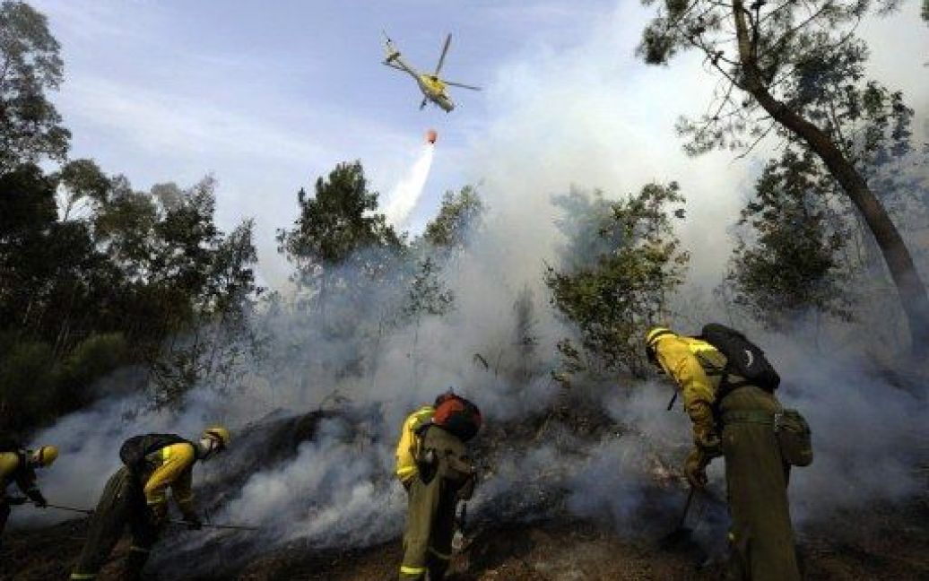 Іспанія, Бара. Вертолет зливає воду на лісову пожужжу, доки пожежні ведуть боротьбу з вогнем у Бара. / © AFP