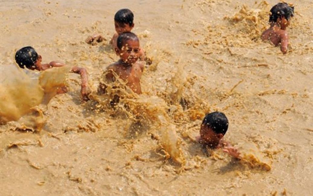 Камбоджа, Самронг. Діти евакуйованих селян, що жили на кордоні із Таїландом, купаються в озері у таборі для біженців. До тайському-камбоджійського кордону була переведена важка техніка після того, як у кривавих сутичках між сусідами загинули 15 людей. / © AFP