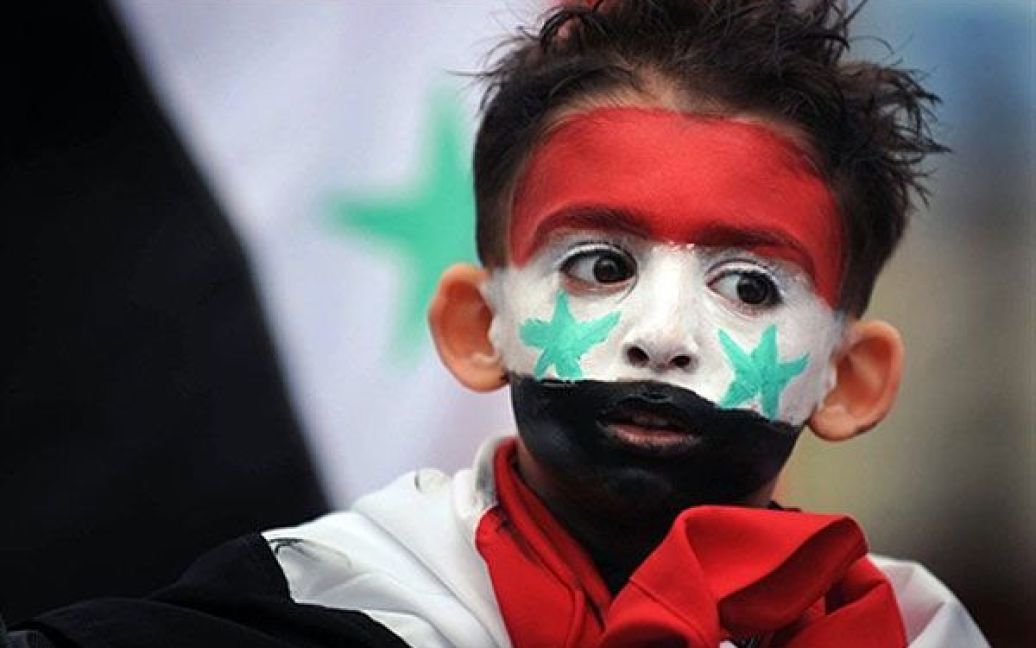 Болгарія, Софія. Хлопчик із пофарбованим обличчям бере участь у мирній демонстрації на підтримку президента Сирії Башара аль-Асада перед посольством Сирії у місті Софія. / © AFP