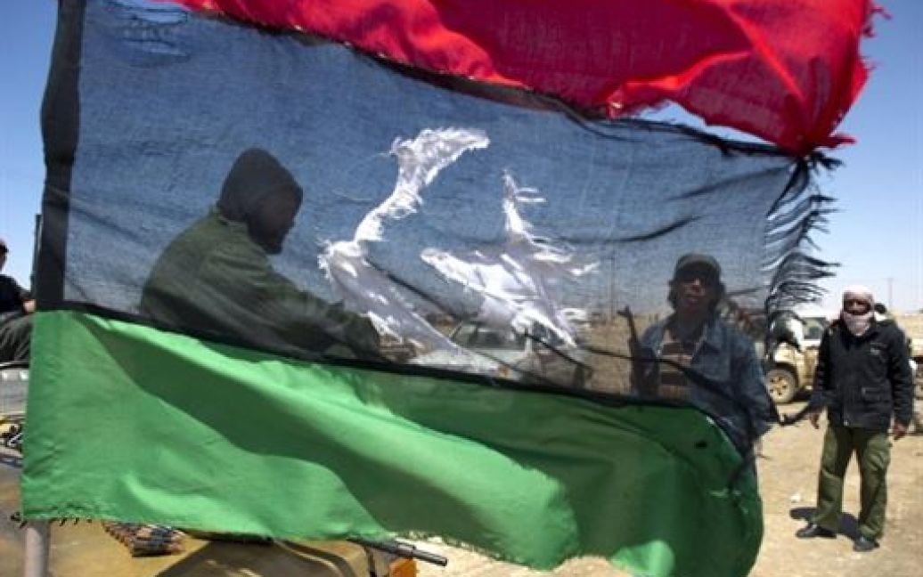 Лівійська Арабська Джамахірія, Аждабія. Повстанці тримають свій прапор на плацдармі поблизу східного міста Аждабія, де, в результаті авіаудару сил НАТО, загинули 35 бійців, що підтримували Муаммара Каддафі. / © AFP