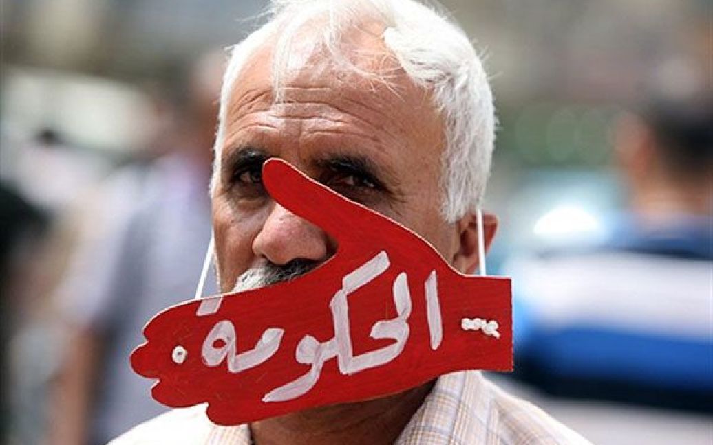 Ірак, Багдад. Іракський демонстрант у масці в формі руки з написом арабською "уряд" бере участь у щотижневій акції протесту проти корупції, безробіття і поганої якості державних послуг у Багдаді. / © AFP