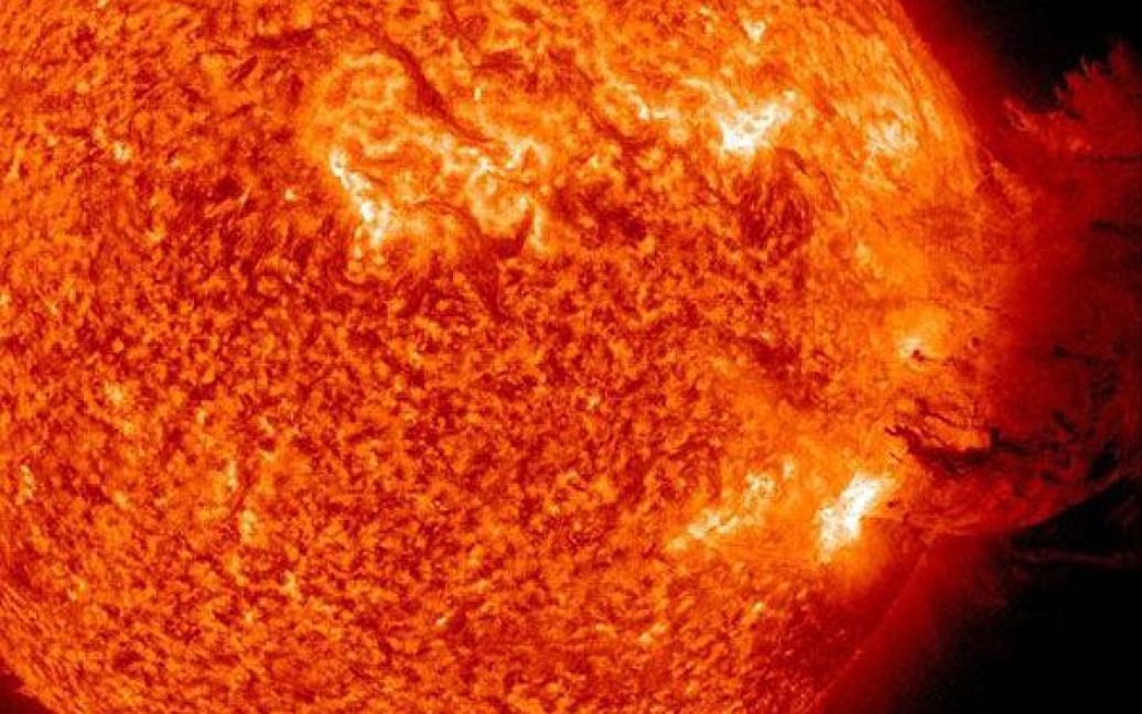 Космос. Астрономи NASA зафіксували потужний та неординарний за своєю красою спалах на Сонці. Викинута з корони світила розпечена плазма, опускаючись, покрила приблизно половину його поверхні. Cпалах може призвести до збоїв в супутниковому зв&#039;язку на Землі. Фото AFP/NASA / © AFP