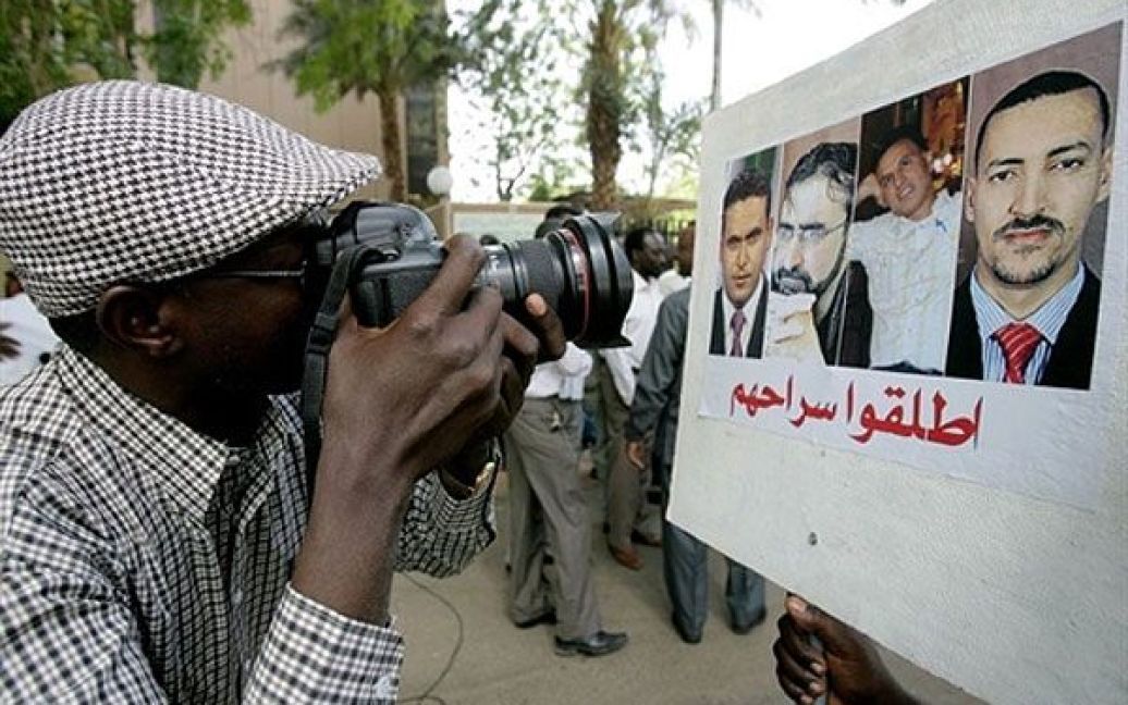 Судан, Хартум. Фотограф робить знімок портретів чотирьох тележурналістів катарського супутникового каналу "Аль-Джазіра", яких перевезли до Тріполі після того, як вони були заарештовані на заході Лівії під час демонстрації. / © AFP
