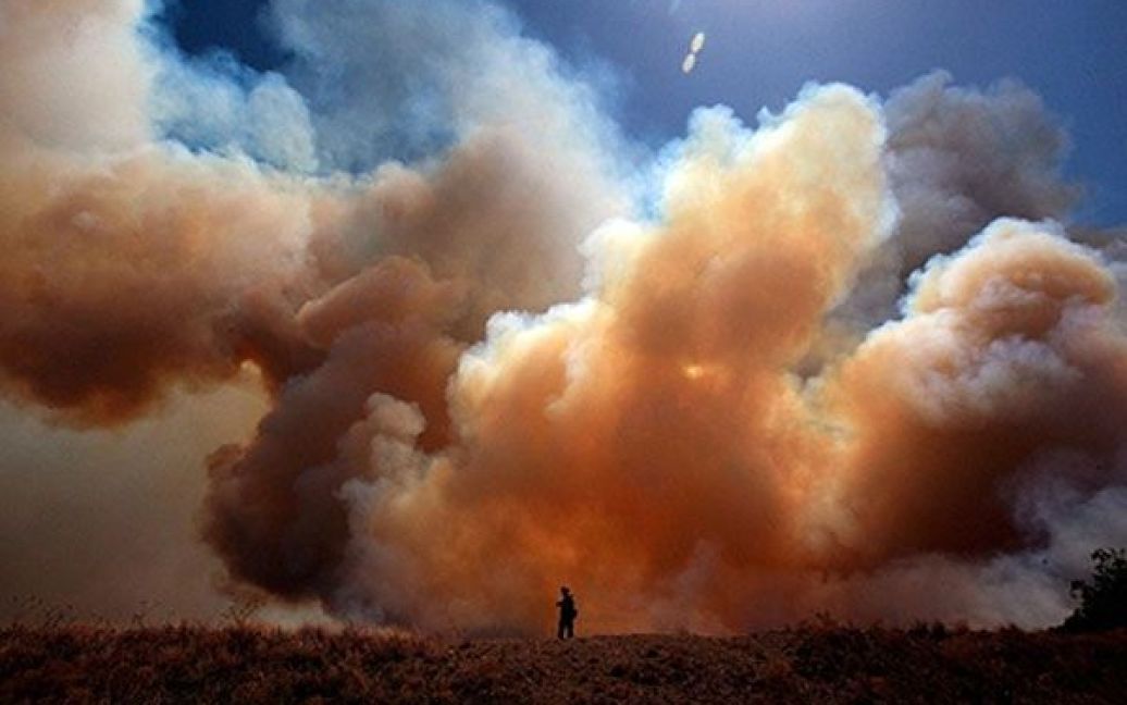 США, Строн, штат Техас. Пожежного Джейсон Лемберт з Сан-Дієго обстежує місце лісової пожежі у місті Строн, штат Техас. Десятки будинків були зруйновані в результаті лісових пожеж, які спричинили засухи, сильний вітер та низька вологість. / © AFP
