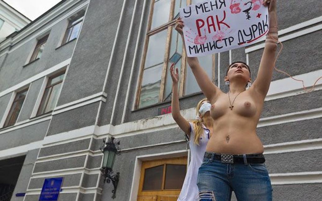 Активістка FEMEN протестувала топлес з плакатами "Я помираю, а ви крадете!", "Епідемія раку совісті", "Momento mori, Yemets!" і "У мене рак, міністре дурак". / © Жіночий рух FEMEN