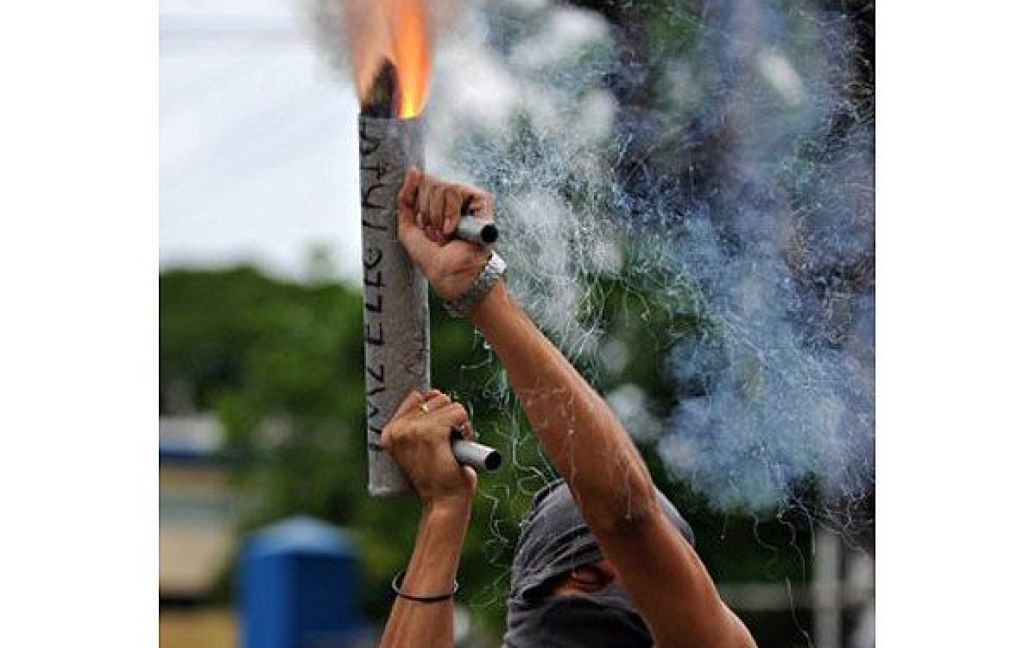 Нікарагуа, Манагуа. Нікарагуанський студент підпалює ракетницю під час акції протесту в Манагуа. Сотні студентів вимагали застосування більш суворих покарань до неповнолітніх правопорушників, адже два тижні тому група неповнолітніх вбила студента Еванса Понсе. / © AFP