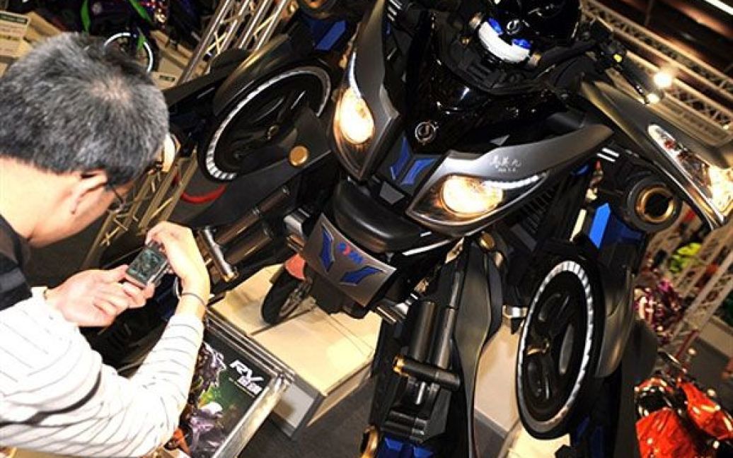 Тайвань, Тайбей. Відвідувач фотографує робота, зібраного з мотоцикла, під час Тайванського мотошоу, яке проходить у Всесвітньому торговому центрі. У чотириденній міжнародній мотовиставці беруть участь більше 250 компаній. / © AFP