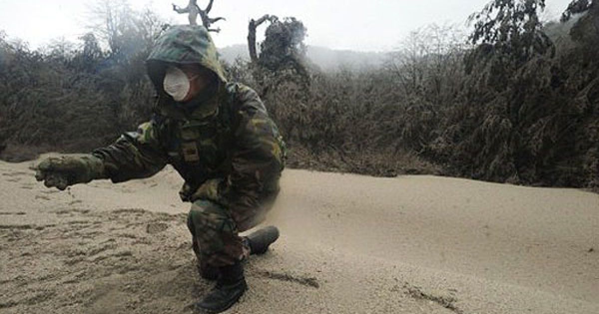 Чилі. Військовий збирає вулканічний попіл поблизу вулкана Пуєйе. Десятки рейсів у Південній Америці були скасовані через величезну хмару вулканічного попелу, який вивергає чилійський вулкан, 4000 осіб були евакуйовані з населених пунктів навколо вулкана Пуєуе. / © AFP