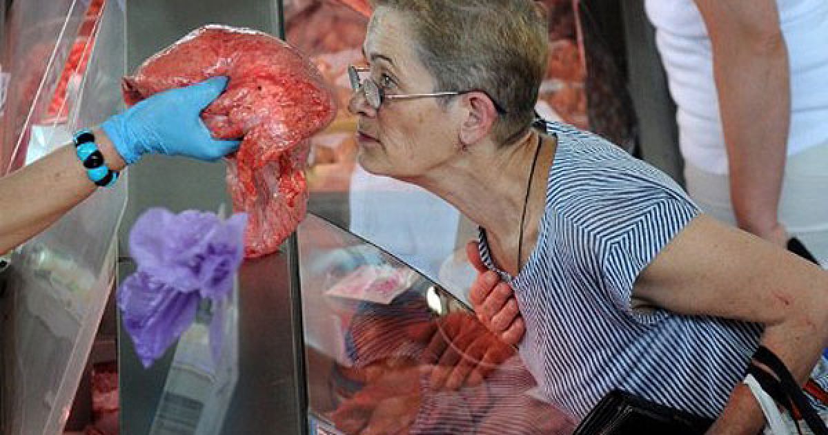 Білорусь, Мінськ. Жінка нюхає шматок м&#039;яса на ринку в Мінську. Споживчі ціни в Білорусі зросли на 36,2% з початку року. В країні зафіксовано найвищий рівень інфляції за останє десятиліття. / © AFP