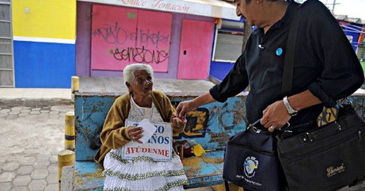 Нікарагуа, Манагуа. 105-річна Корнелія Гомес сидить на автобусній зупинці з табличкою "Мені 105 років, допоможіть мені". Гомес, яка є однією з найстаріших людей планети, жебракує на вулиці протягом восьми років, сподіваючись, що уряд допоможе їй. / © AFP