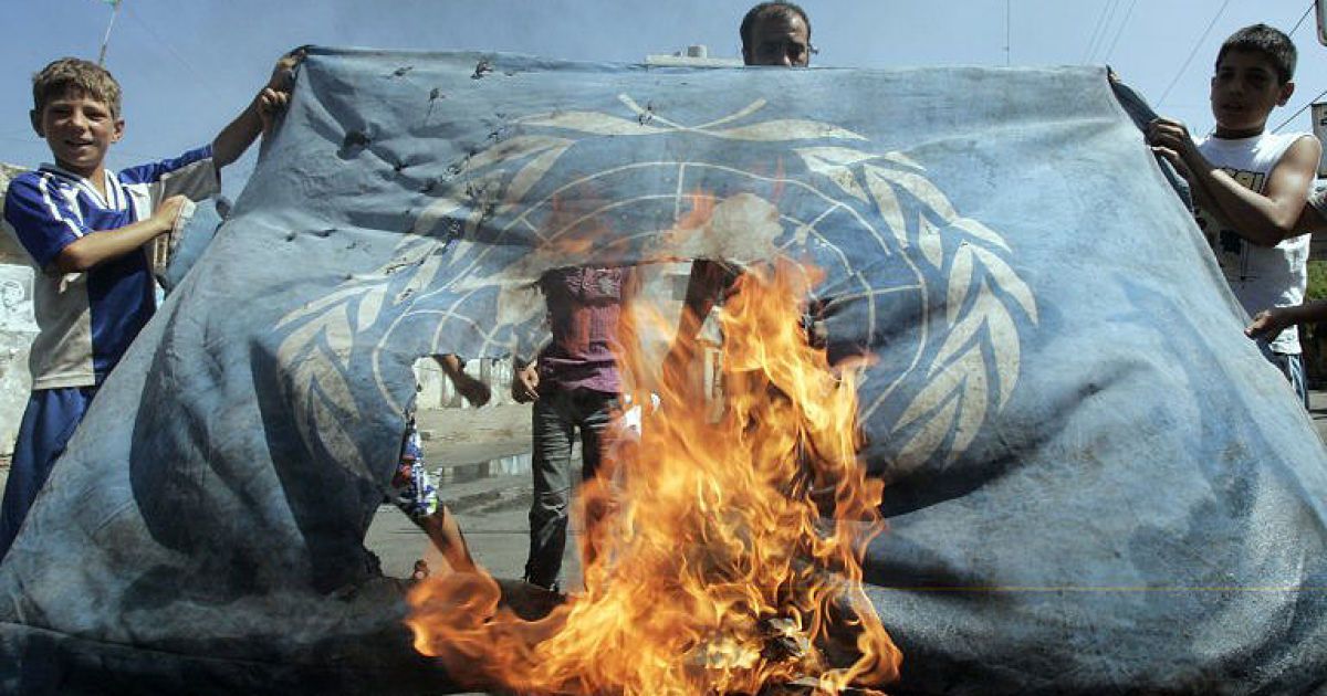 Ліван. Палестинські біженці, які проживають на околиці південного ліванського портового міста Сідон у таборі для біженців, підпалюють прапор БАПОР (агентства ООН для палестинських біженців) на знак протесту проти погіршення умов життя палестинських біженців, що проживають у Лівані. / © AFP