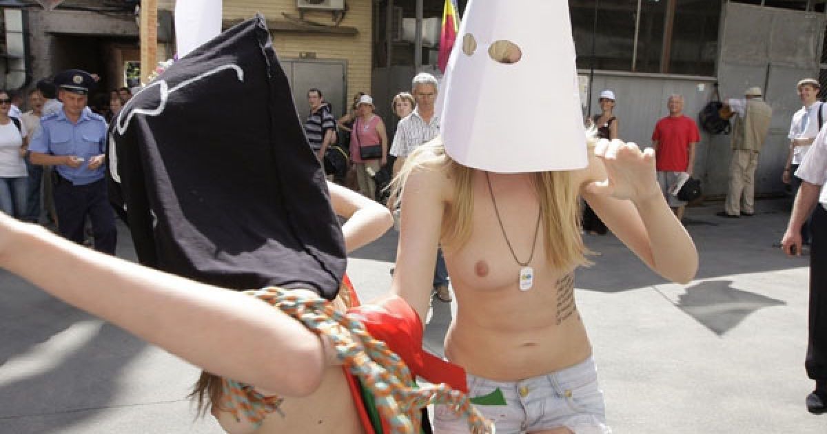 Оголені дівчата з руху FEMEN у ковпаку ката та з макетом сокири в руках почали імітувати страту з криками "Забій кролятини".