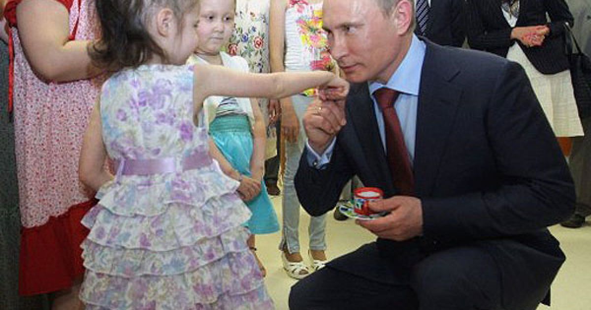 Росія, Москва. Прем&#039;єр-міністр Росії Володимир Путін цілує руку дівчини під час відвідування відкриття нового дитячого медичного центру в Москві. / © AFP