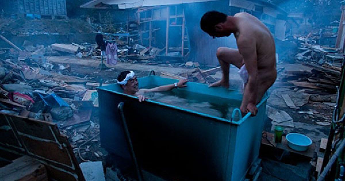 Японія, Мінамісанріку. Місцеві мешканці приймають ванну на вулиці зруйнованого цунамі місті Мінамісанріку, префектура Міягі. / © AFP