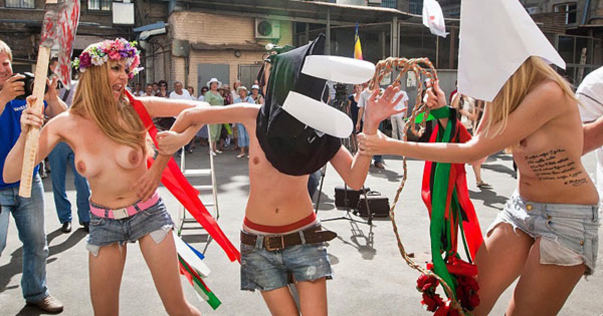 Оголені дівчата з руху FEMEN у ковпаку ката та з макетом сокири в руках почали імітувати страту з криками "Забій кролятини".
