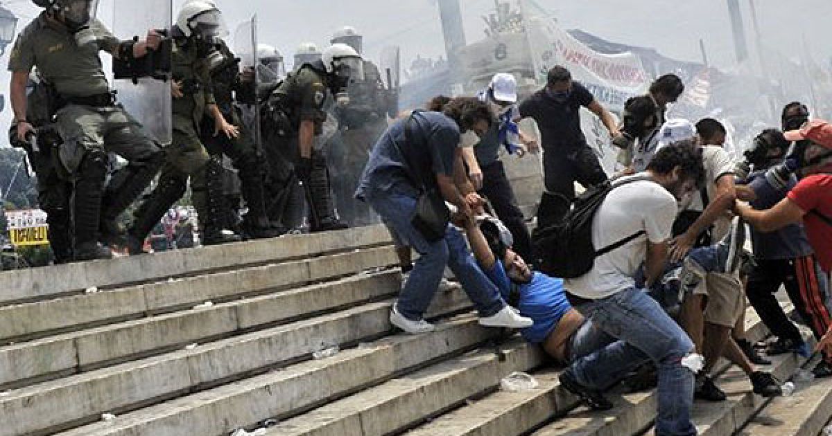 Греція, Афіни. Демонстранти переносять свого товариша, який впав під час запеклих зіткнень з ОМОНом перед грецьким парламентом. Законодавці греції ухвалили повний пакет заходів жорсткої економії в країні, яких вимагають міжнародні кредитори. / © AFP