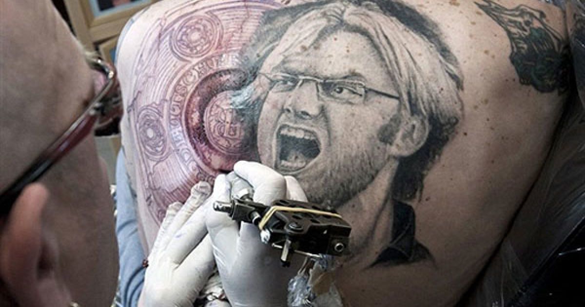 Німеччина, Унна. Шанувальнику німецького ФК першого дивізіону Бундесліги "Боруссія" (Дортмунд) на спині роблять татуювання у вигляді портрету тренера клубу Юргена Клоппа і трофею Бундесліги. / © AFP