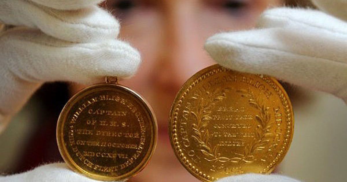 Австралія, Мельбурн. Співробітник "Nobles Numismatics" тримає дві цінні золоті медалі, якими був нагороджений капітан Вільям Блай. Медалі продадуть в Мельбурні, де відбудеться один з найбільших "морських історичних" аукціонів. / © AFP