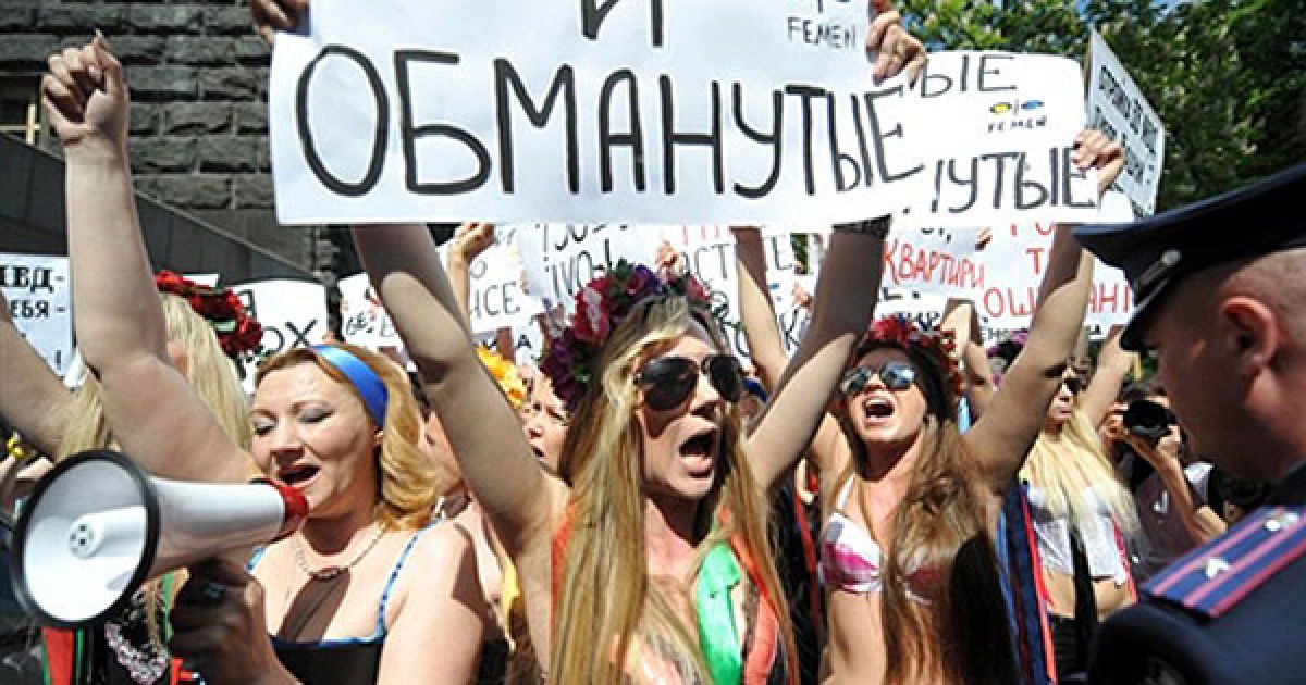 Україна, Київ. Активістки руху FEMEN та ошукані інвестори будівельних компаній провели акцію протесту "Голі та ошукані" перед будівлею Кабміну в Києві. Вони вимагали завершення проектів, в які вклали гроші інвестори. / © AFP