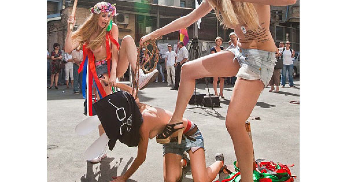 Оголені дівчата з руху FEMEN у ковпаку ката та з макетом сокири в руках почали імітувати страту з криками "Забій кролятини".