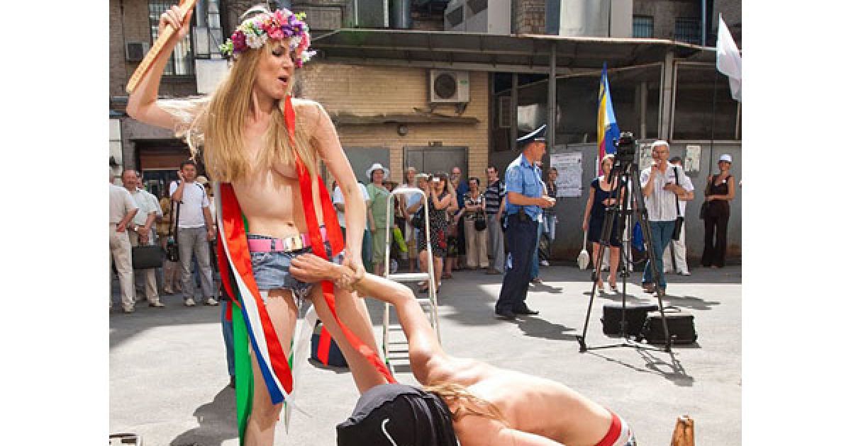 Оголені дівчата з руху FEMEN у ковпаку ката та з макетом сокири в руках почали імітувати страту з криками "Забій кролятини".