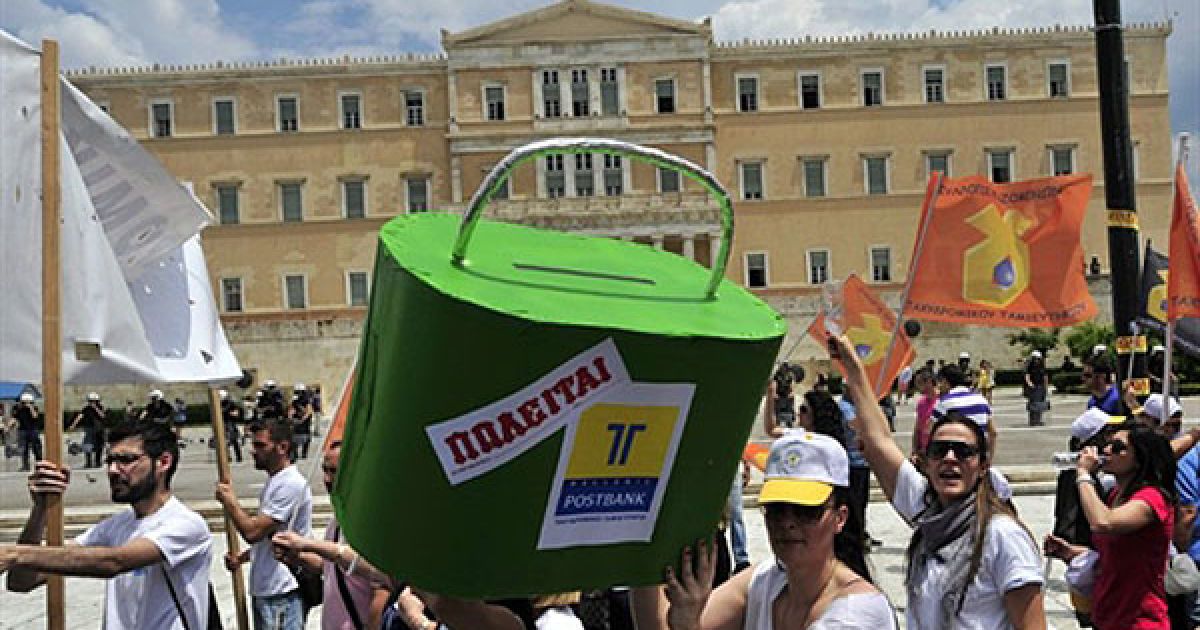 Греція, Афіни. Співробітники грецького холдингу "Postbank" несуть макет сейфу компанії з написом "Для продажу" під час акції протесту перед будівлею парламенту Греції в Афінах. Вони провели 24-годинний страйк проти приватизації компанії. / © AFP
