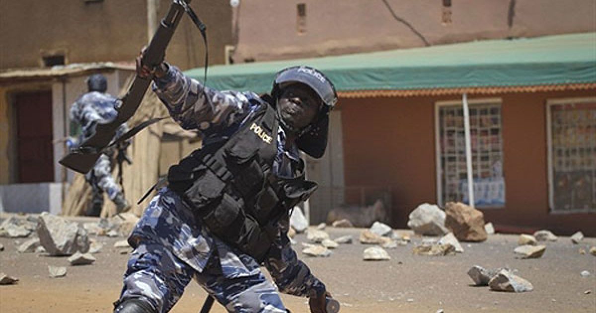 Уганда, Кампала. Поліцейський кидає сльозоточивим газом у демонстрантів, які у відповідь жбурляють в поліцію камінням. Сили безпеки заблокували мирну демонстрацію опозиції та спробували заарештувати лідерів опозиції. / © AFP