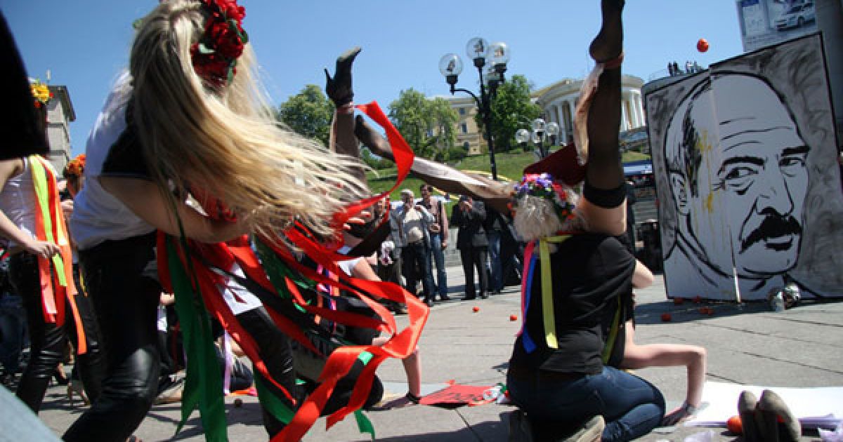 Дівчата з руху FEMEN у відвертих позах "рогаток" закидали яйцями і помідорами портрет президента Білорусі Олександра Лукашенка. / © Жіночий рух FEMEN