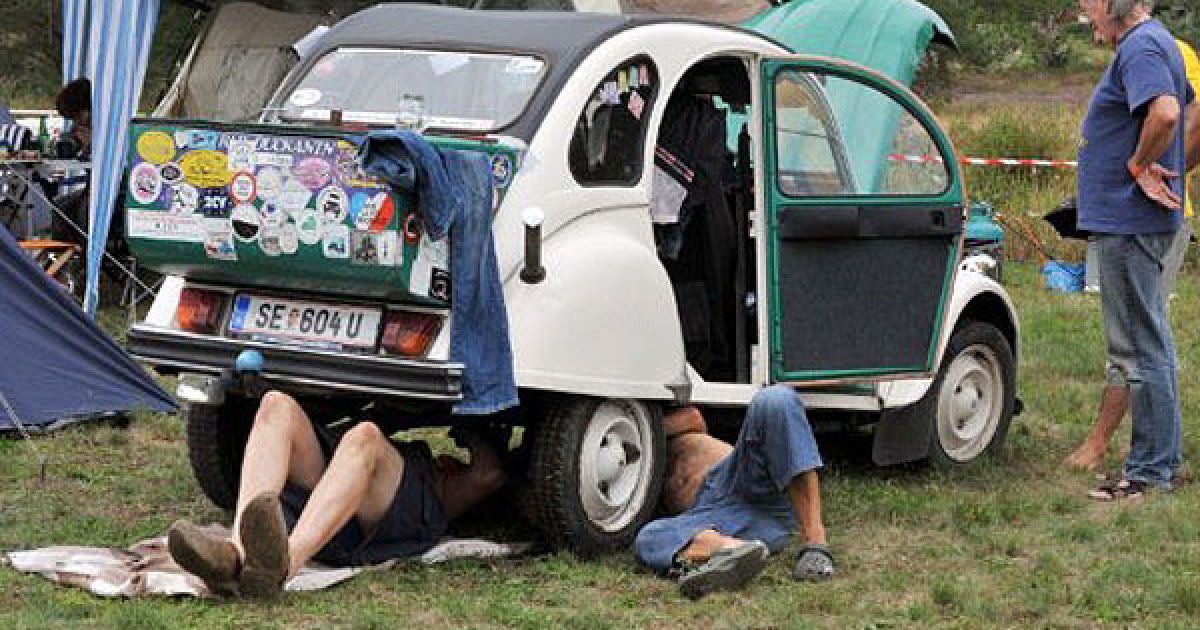 Франція, Сальбрі. Австрійці ремонтують свій автомобіль Citroen 2CV під час проведення 19-ої всесвітньої зустрічі "Друзів 2CV", яка проходитиме до 31 липня 2011 року. Рекордна кількість автомобілів 2CV (більш ніж 2650) зібралася у Сальбірі у 2006 році. / © AFP