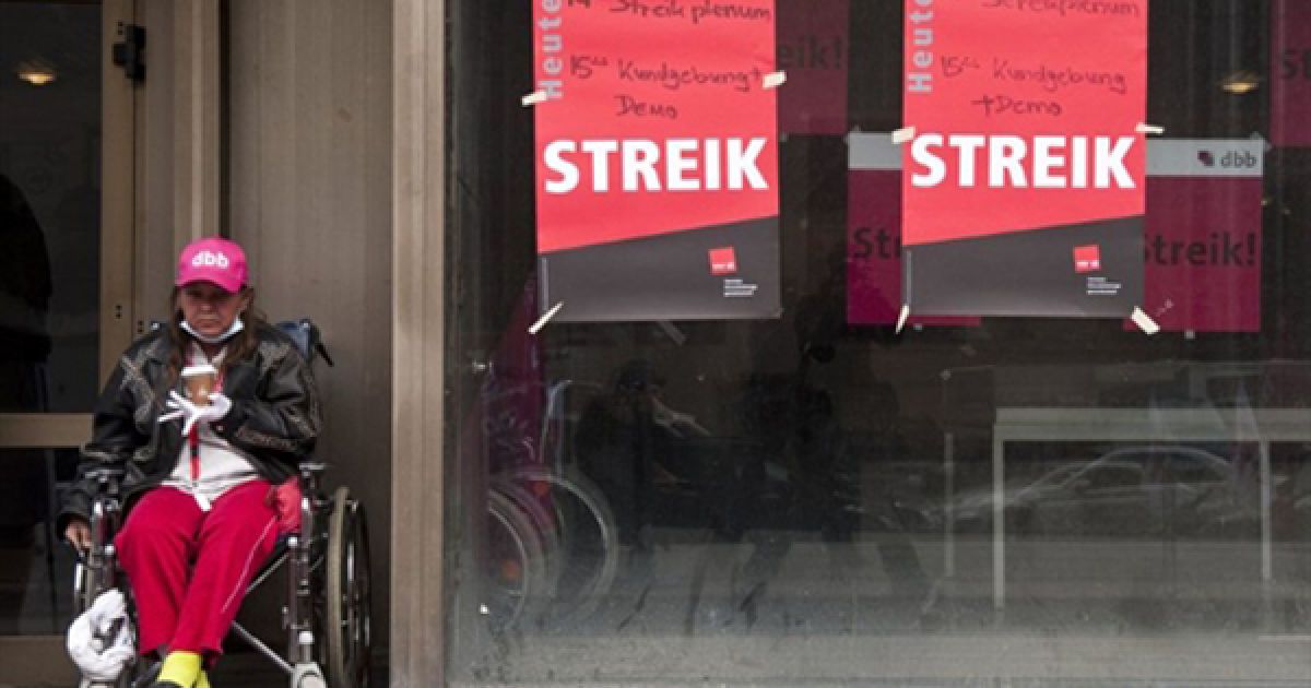 Німеччина, Берлін. Жінка у інвалідному візку сидить біля зачинених дверей госпіталю Charite Mittе. Більше 10 тисяч медичних співробітників оголосили страйк з вимогою підняти зарплати до 300 євро на місяць. / © AFP