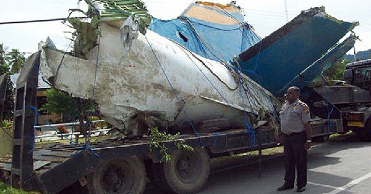 Індонезія, Каймана. Поліцейський оглядає хвіст літака MA-60 компанії "Мерапі Нусантара", який розбився в провінції Західне Папуа. Літак впав у море, коли він наближався до аеропорту в районі Каймана під час сильного дощу. / © AFP