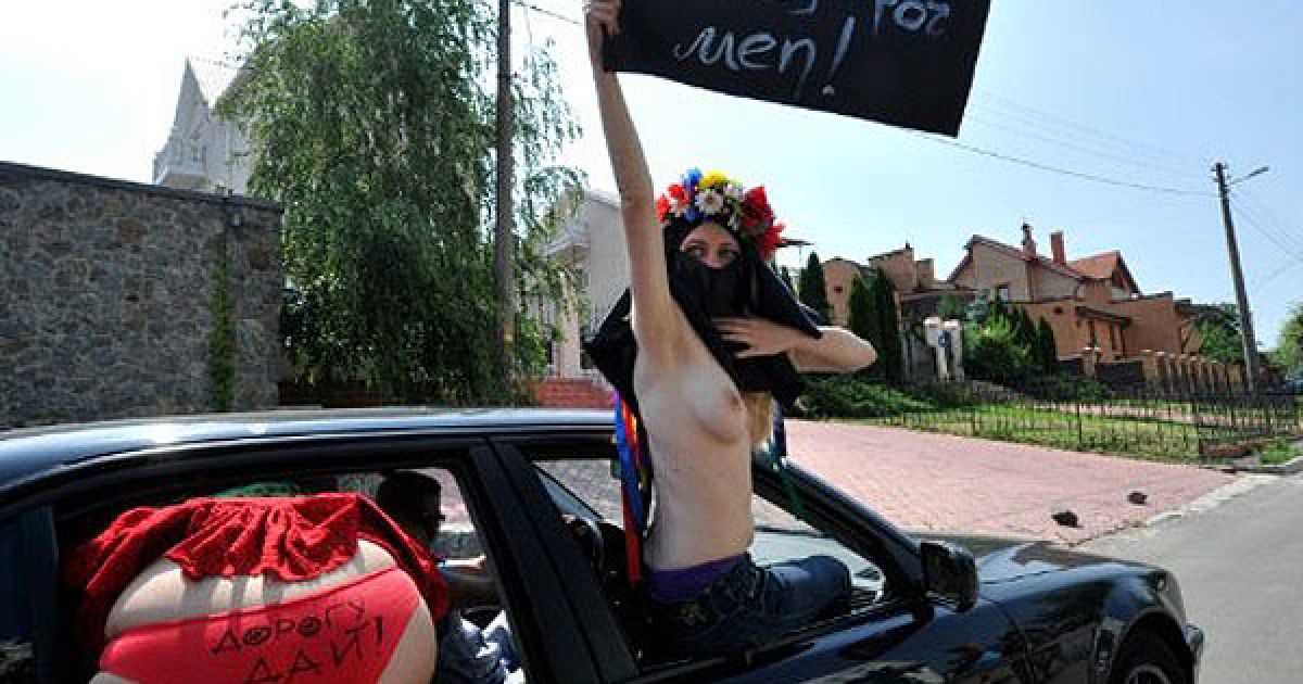 Україна, Київ. Активістки жіночого руху FEMEN вигукують гасла під час топлес-акції протесту "Дай дорогу!" перед посольством Саудівської Аравії в Києві. Українські феміністки підтримали саудівських жінок, яким заборонять сідати за кермо автомобіля з 17 червня. / © AFP