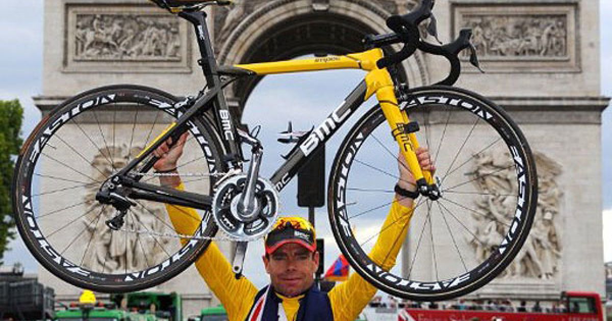 Франція, Париж. Австралійський велогонщик Кадель Еванс тримає жовту майку загального лідера велогонки, стоячи перед на своєму велосипеді перед Тріумфальною аркою на Єлисейських Полях в Парижі. Австралієць виграв велогонку "Тур де Франс 2011". / © AFP