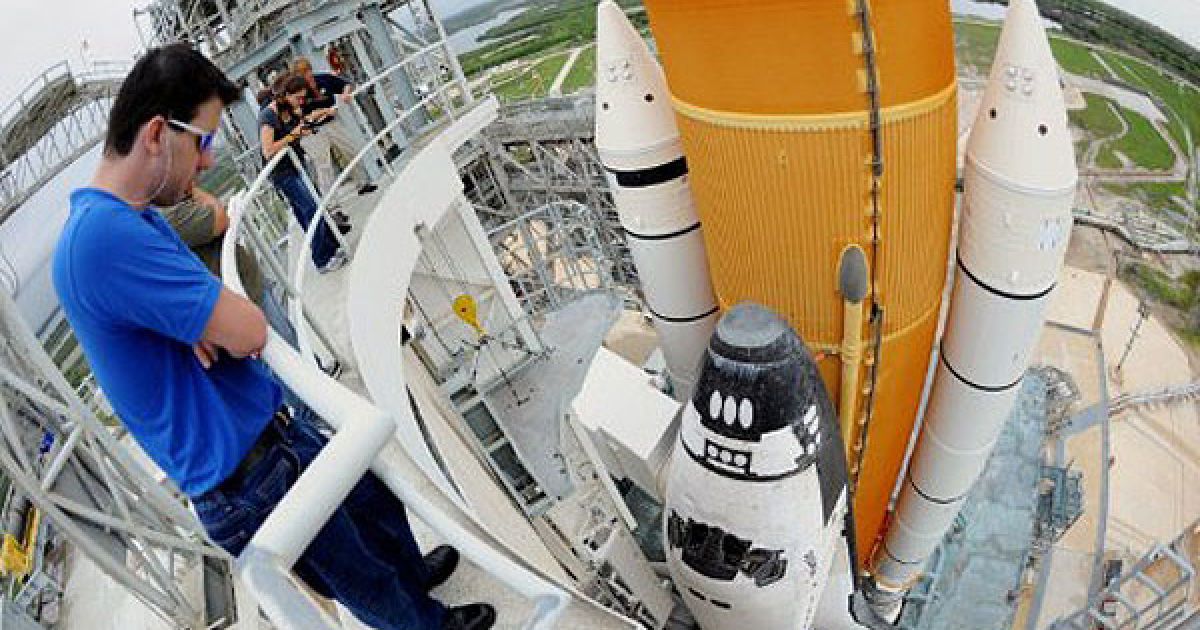 США, космічний центр Кеннеді. Працівник дивиться згори на шаттл Atlantis, встановлений на стартовому майданчику перед останнім польотом в космос. / © AFP