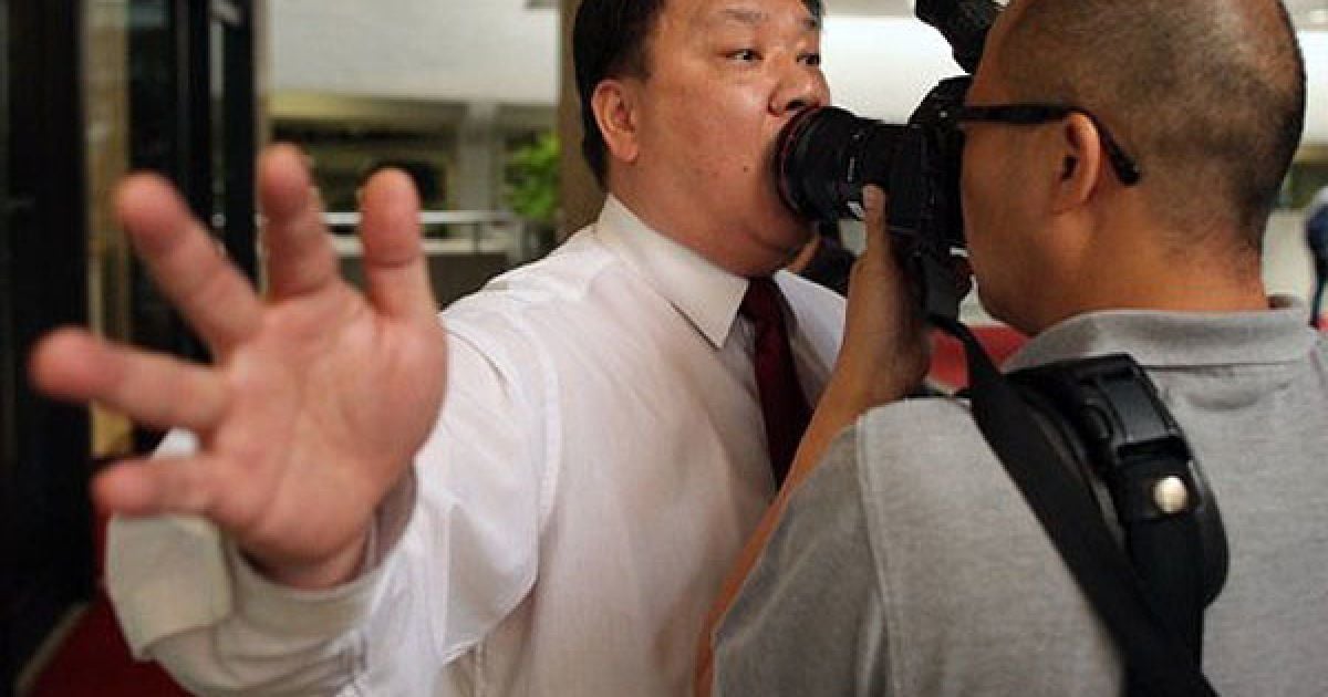 Китай, Гонконг. Охоронець намагається зупинити фотографа, який знімає учасників акції протесту, що закликають звільнити затриманого тайського правозахисника Сомйота Пруксакасемсука, перед тайським консульством в Гонконзі. / © AFP