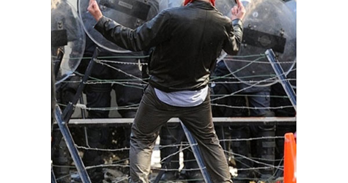 Бельгія, Брюссель. Демонстрант жестикулює, стоячи перед поліцейським кордоном, під час акції протесту профспілок, яку провели перед початком саміту ЄС в Брюсселі. / © AFP
