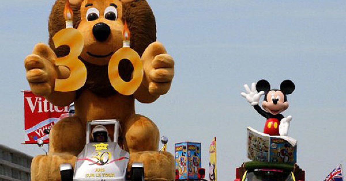 Франція, Ле Есаром. Велосипедисти від банку Le Credit Lyonnais та Le Journal de Mickey беруть участь в параді реклами перед початком другого етапу велогонки Тур де Франс 2011. / © AFP