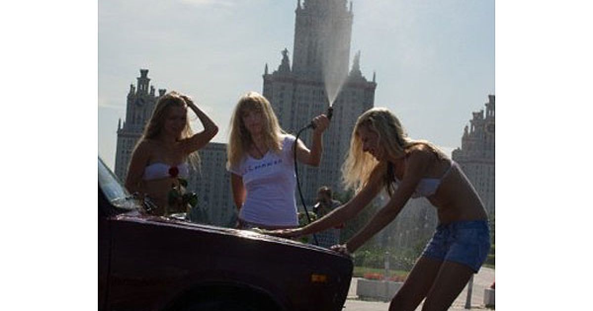 Росія, Москва. Молоді жінки з соціального руху "Мені дуже подобається Путін" миють автомобіль під час акції перед будівлею Московського державного університету. Активістки під час акції безкоштовно мили лише автомобілі російського виробництва. / © AFP