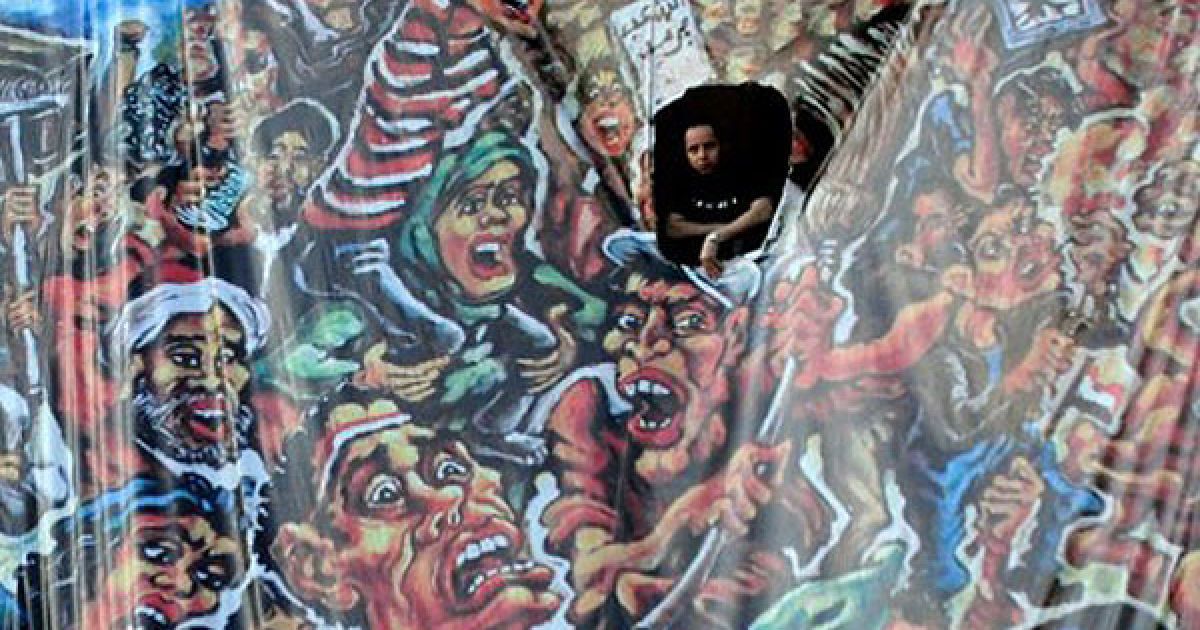 Єгипет, Каїр. Людина спостерігає, як тисячі демонстрантів збираються на площі Тахрір в Каїрі перед акцією протесту. Демонстранти вимагали політичних змін в країні та висловлювали незадоволення новою владою і прем&#039;єр-міністром Єгипту Ессамом Шарафом. / © AFP