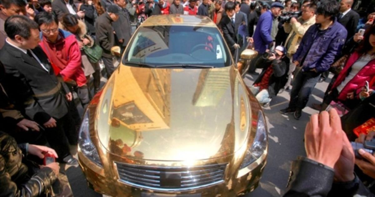 Китай, Нанкін. Натовп роздивляється позолочений розкішний спортивний автомобіль Infiniti, виставлений перед ювелірним магазином у Нанкіні. / © AFP