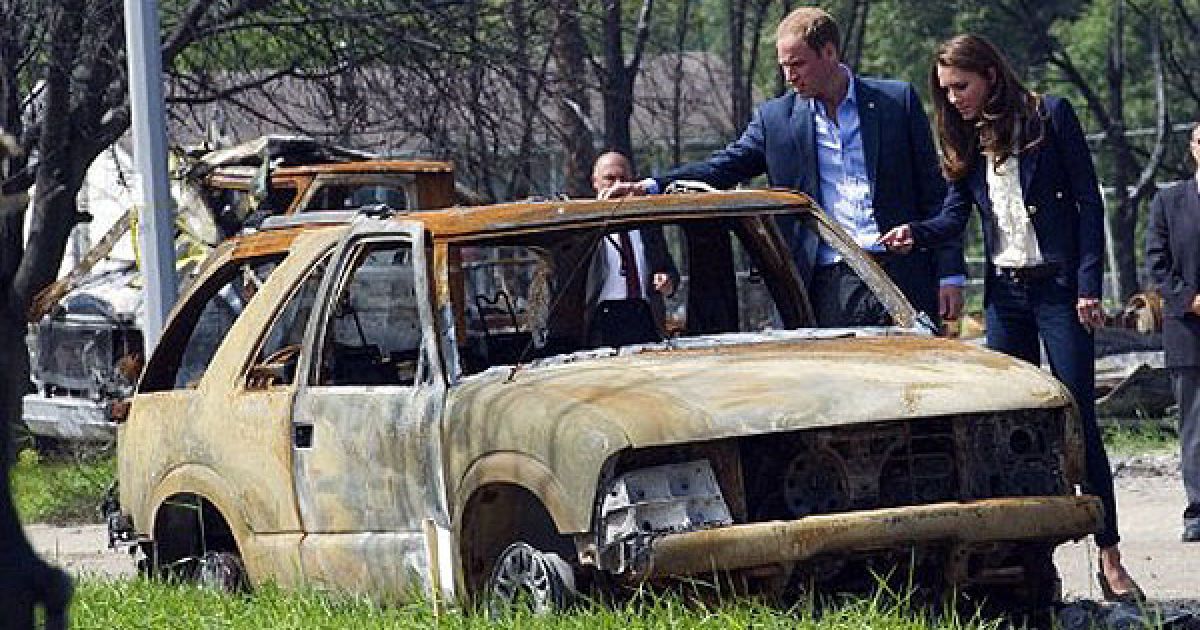 Канада, Слейв Лейк. Британський принц Вільям зі своєю дружиною Кейт, герцогинею Кембриджською, роздивляються пошкоджений автомобіль під час візиту до міста Слейв Лейк, зруйнованого в результаті лісової пожежі. / © AFP