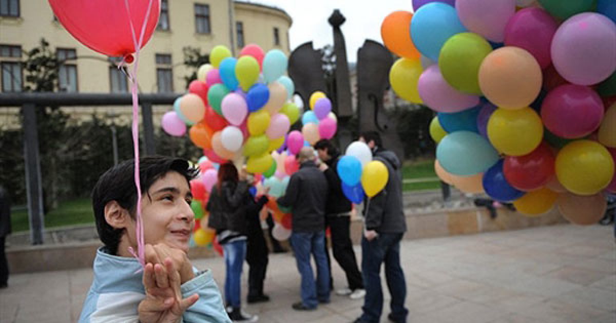 Румунія, Бухарест. Дитина-аутист посміхається під час мітингу, присвяченого Всесвітньому дню артистів. / © AFP