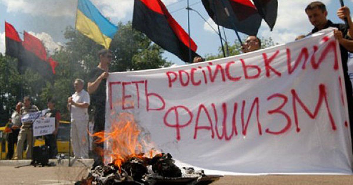 Україна, Київ. Українські націоналісти тримають плакат "Геть російський фашизм" після урочистого спалення ленти Святого Георгія під час мітингу перед будівлею посольства РФ в Києві. В Україні відзначили 70 років з моменту вторгнення фашистської Німеччини на територію СРСР. / © AFP