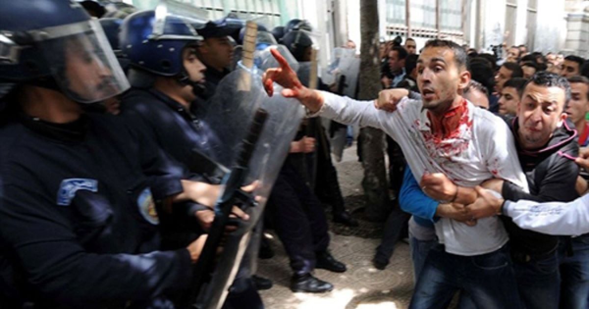 Алжир. Поранений протестувальник намагається поговорити з поліцейськими. У Алжирі спалахнули акції протесту студентів, незадоволених владою. На даний момент будь-які демонстрації на півночі Алжиру заборонені, але молодь все одно виходить на вулиці. / © AFP