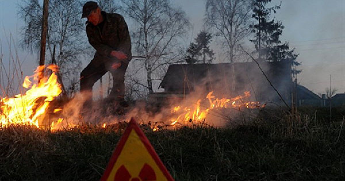 Білорусь, Рудноє. Чоловік контролює вогонь під час підготовки парового поля у покинутому селі Рудноє у 30-кілометровій зоні відчуження навколо Чорнобильської АЕС. / © AFP